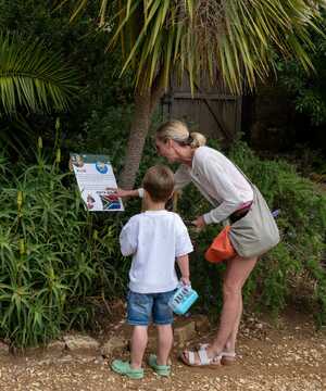 A woman and a child examine a follow the Lancaster the Explorer trail