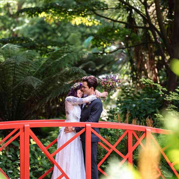married couple standing on a red bridge at abbotsbury subtropical gardens